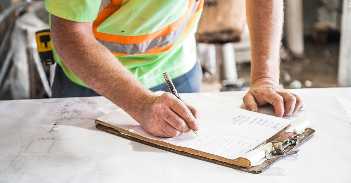 Man in high-vis clothing completes a checklist