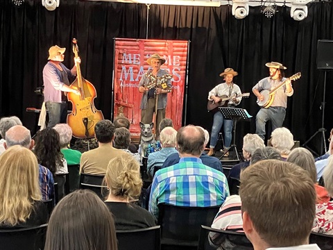 4 Band mates playing on stage in front of a crowd